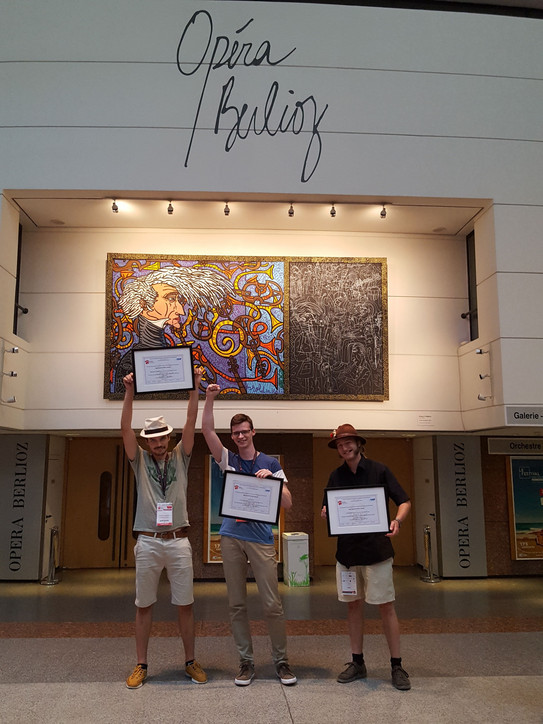 The three ICPS 18 poster award winners of TRR 160, Aleksandr N. Kamenskii, Ivan A. Solovev, and Erik Kirstein in front of the main conference hall.